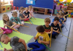 Dzieci w dwóch rzędach naśladujące wiosłowanie za pomocą lasek- włoskie gondole